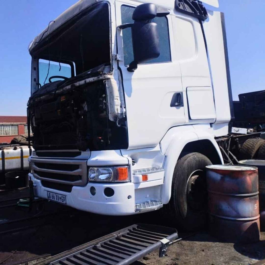 White heavy-duty semi-truck repair at HiTech-repairs, showing exposed engine bay and front chassis during service.